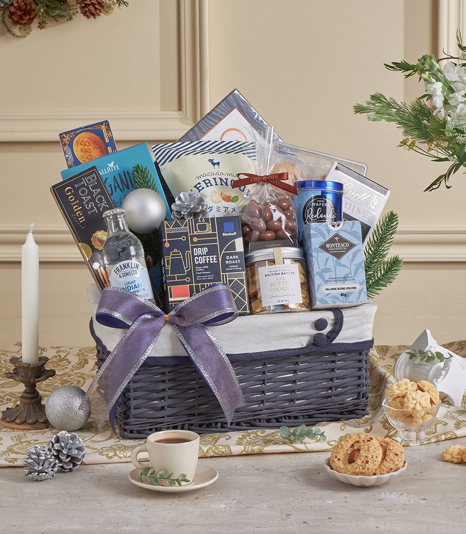 Luxury gourmet gift basket with premium coffee, tea, cookies, and macadamia wafers, tied with purple ribbon for New Year