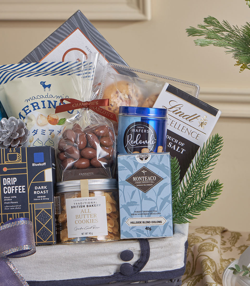 Blue luxury gourmet gift basket with macadamia nuts, chocolate-covered almonds, wafers, Lindt chocolate, coffee, artisan