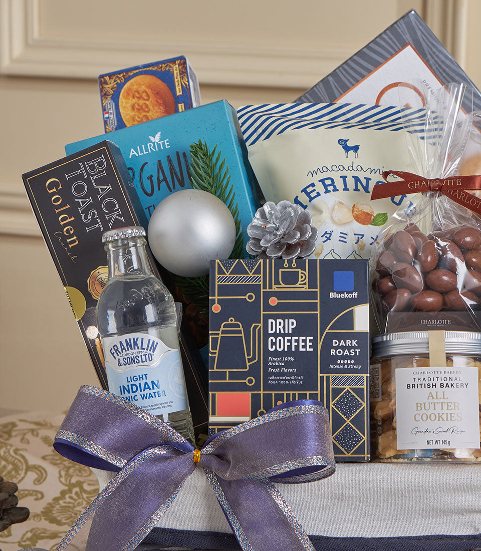 Blue luxury gourmet gift basket with premium coffee, nuts, organic snacks, and Charlotte Bakery cookies, tied with silver