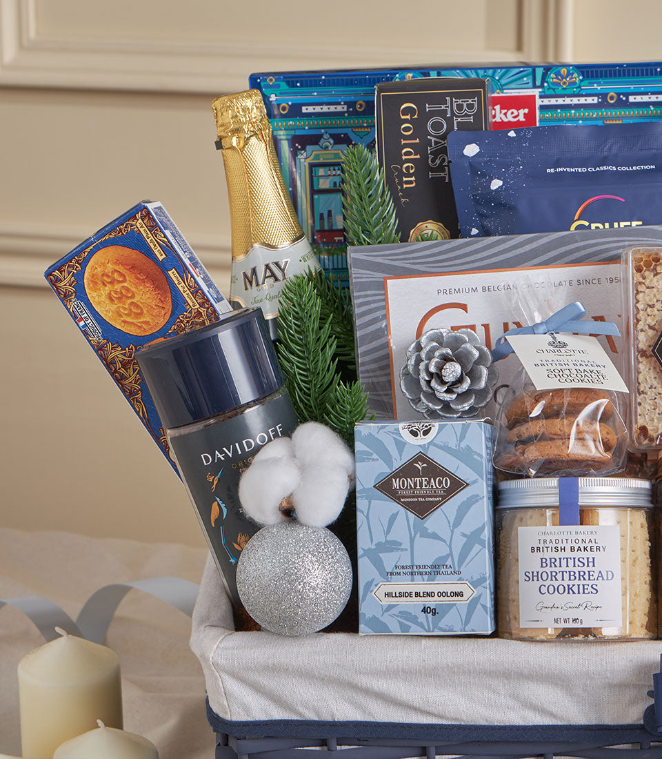 Blue elegant gourmet gift basket with sparkling wine, coffee, tea, and artisan biscuits for New Year celebrations