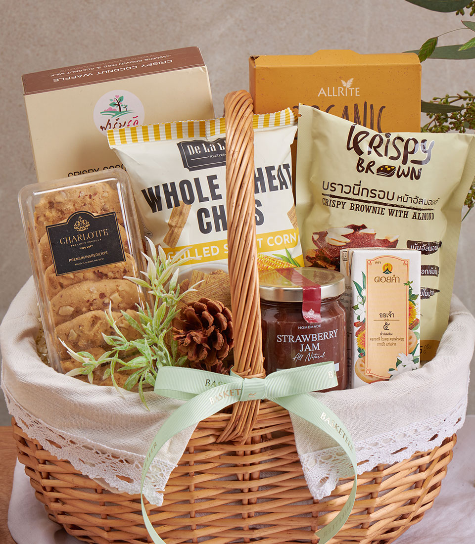 Premium wellness gift basket with coconut waffle, whole wheat chips, brownies, and Charlotte cookies in woven wicker