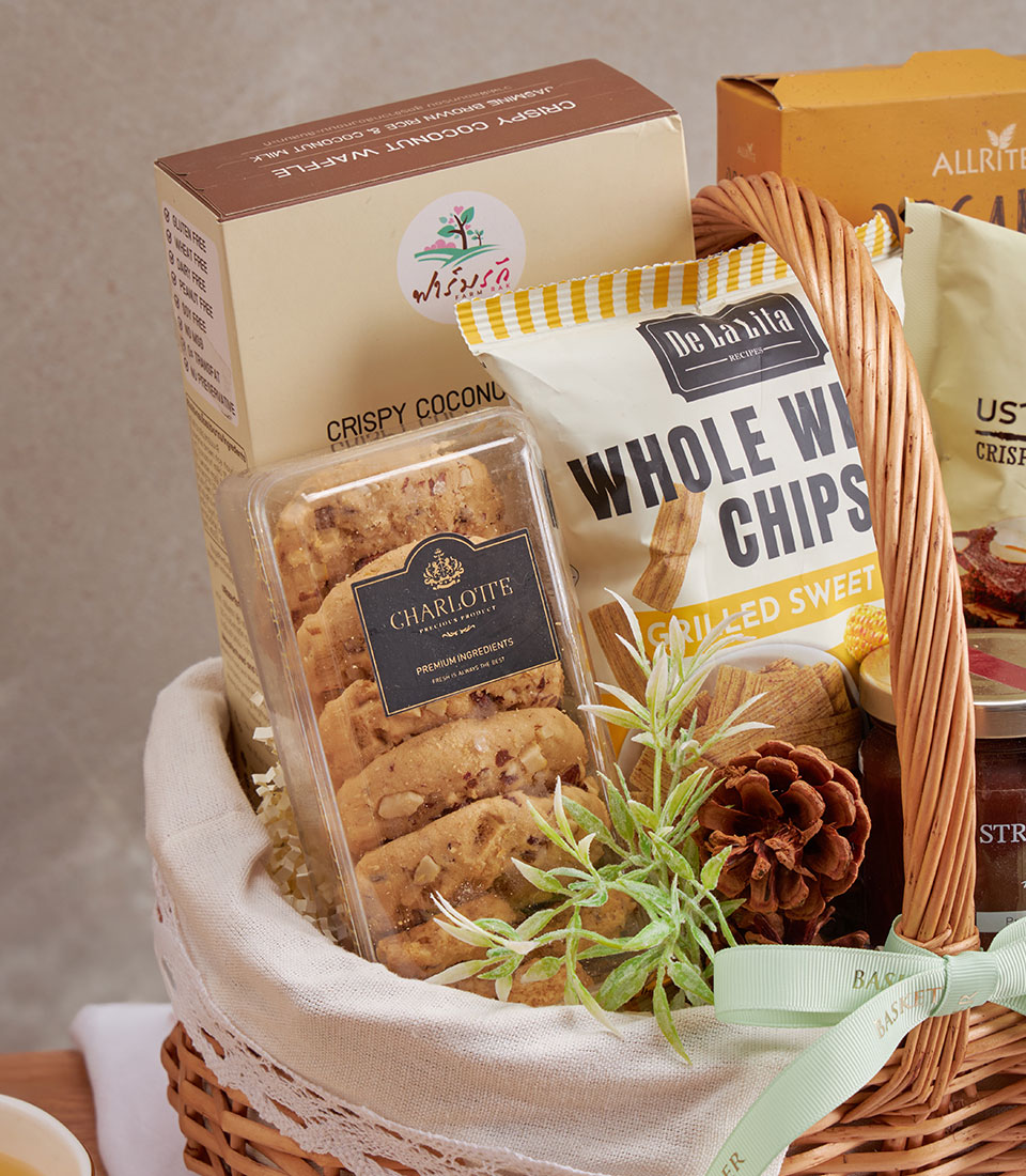 Premium wellness gift basket with coconut waffle, whole wheat chips, gourmet cookies in woven wicker and white lace lining