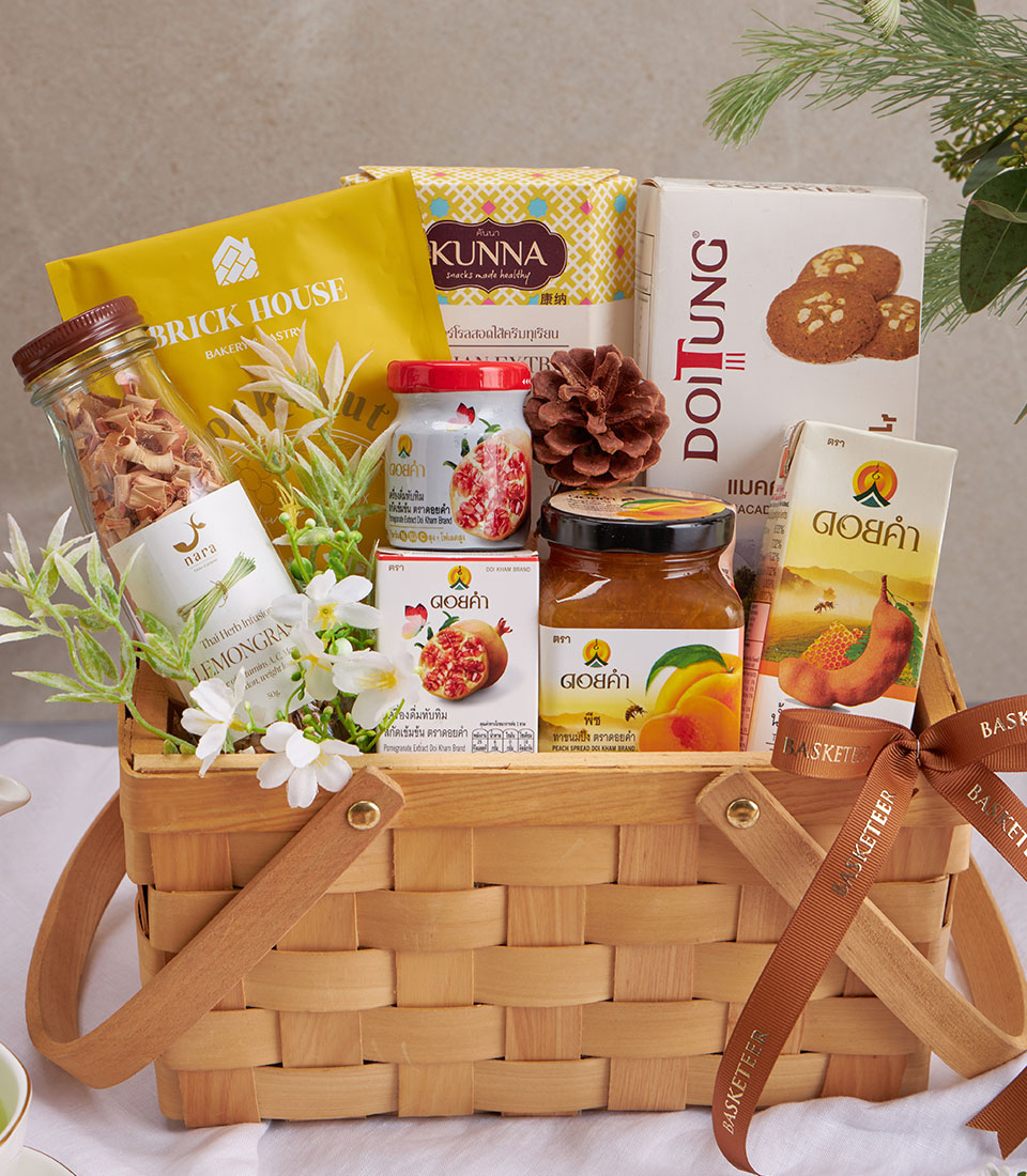 Premium wellness gift basket with herbal tea, healthy snacks, and artisan preserves in woven wood