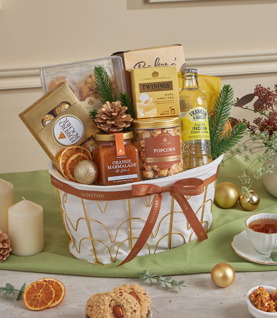 Premium almond and citrus gourmet gift basket with chocolates, tea, marmalade, and festive gold accents for New Year gifting
