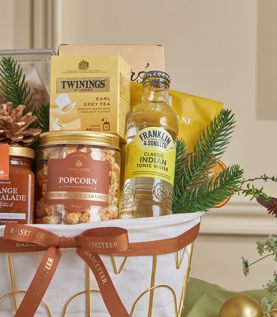 Gold wire gift basket with almond snacks, citrus tea, and artisan treats for New Year celebrations
