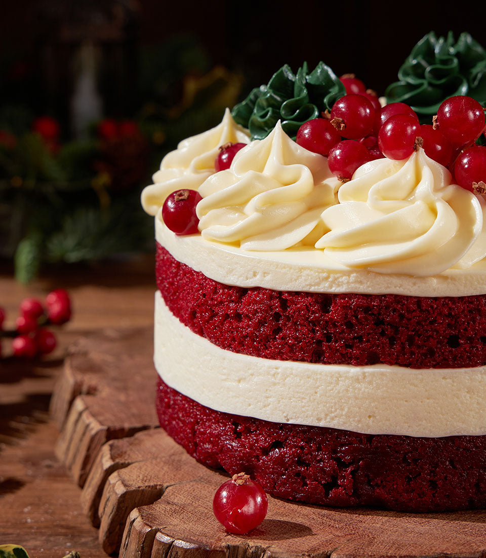Red velvet layer cake with cream cheese frosting and festive berry garnish, Christmas celebration cake