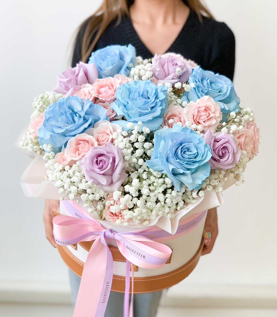 Luxe floral hatbox with blue, pink, and lavender roses, fresh-cut Ecuador blooms in white presentation box