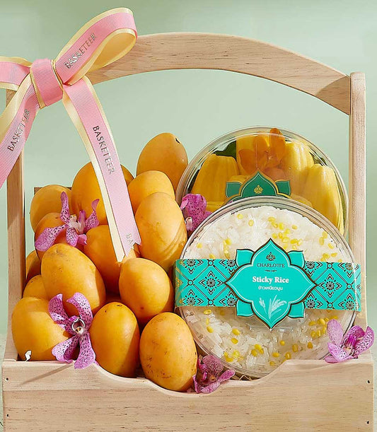 Wooden gift basket overflowing with ripe yellow mangoes, purple orchids, jackfruit, and sticky rice with yellow beans in