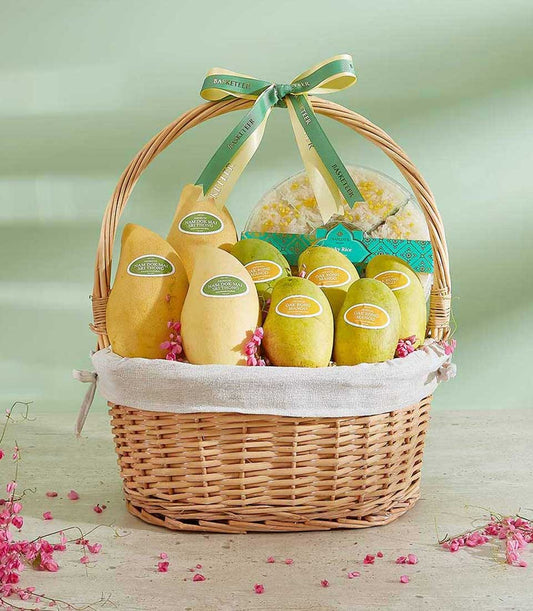 Woven gift basket with Nam Dok Mai and Oak Rong mangoes, sticky rice dessert, and fresh pink flowers