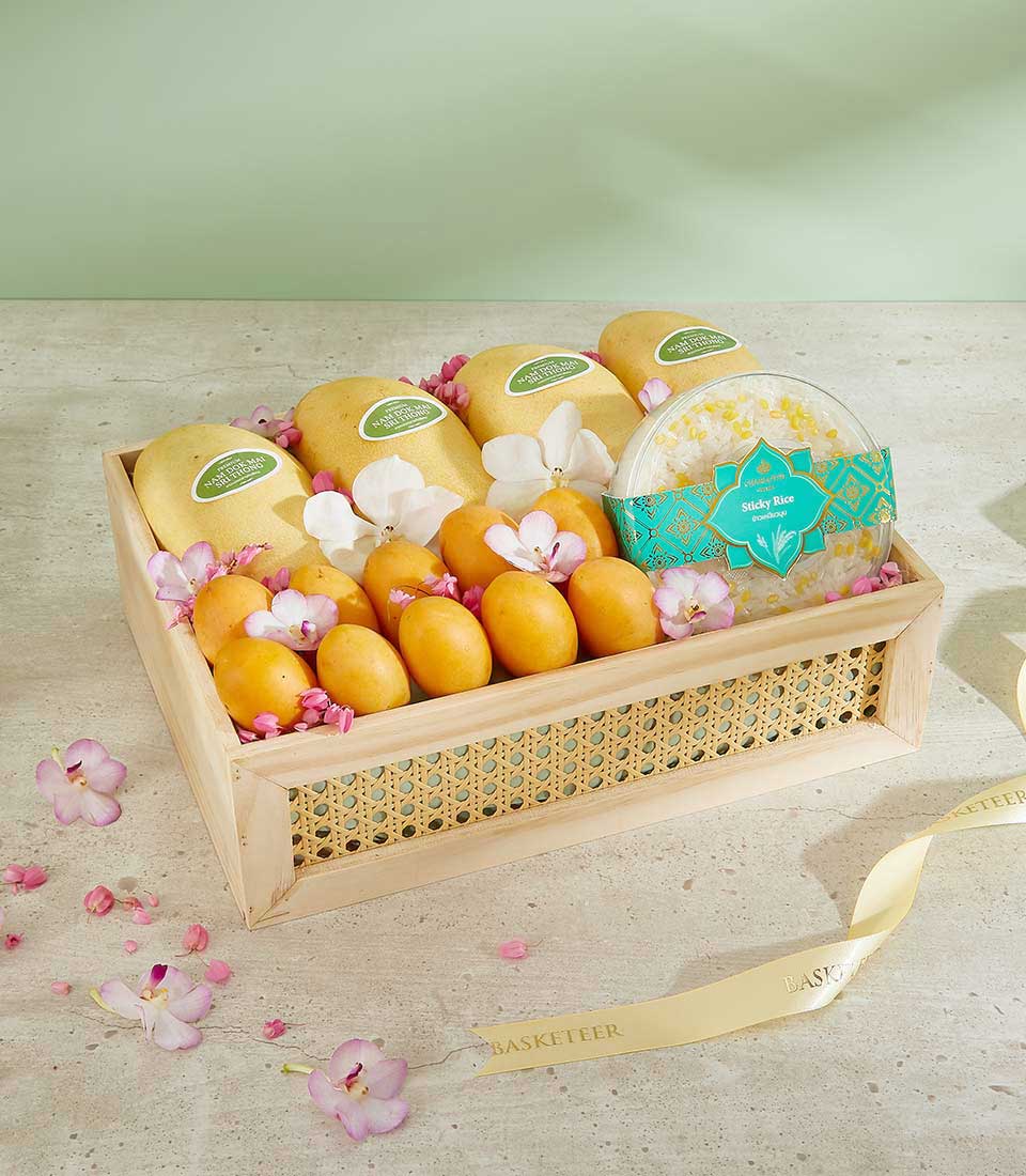 Luxury tropical fruit gift basket with Thai mangoes, sticky rice, and fresh orchids in woven wooden hamper