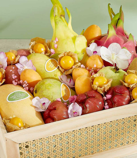Luxury wooden crate gift basket filled with Thai exotic fruits, mangoes, dragon fruit, and fresh orchids
