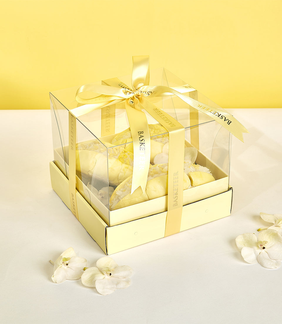 Premium Monthong durian gift box with yellow satin ribbon and orchid flowers on white surface