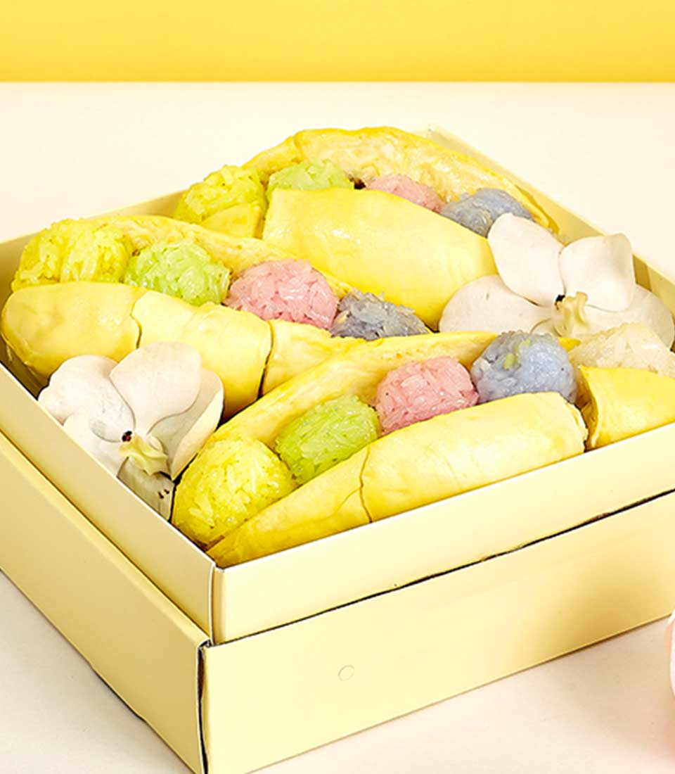 Vibrant Monthong durian gift box with pastel sticky rice clusters and white orchid flowers