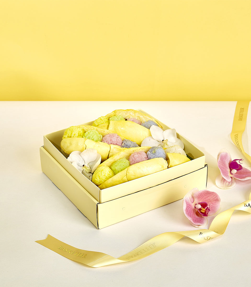 Premium Monthong durian gift box with tropical fruits, pastels, and orchids in luxury yellow presentation