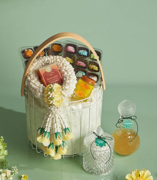 Thai Songkran blessing gift basket with white floral garland, gourmet desserts, perfume powder, and scented water