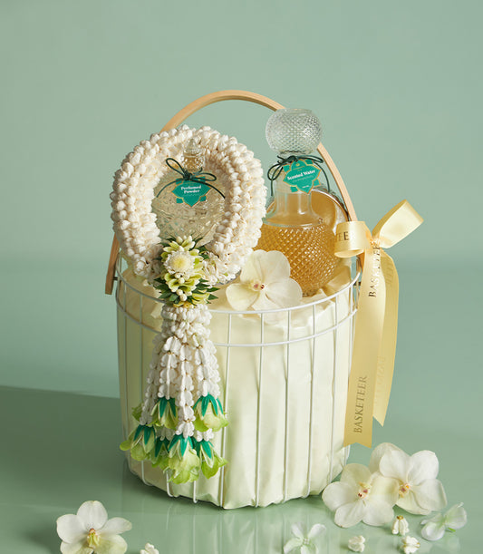 Graceful white wire gift basket with Songkran perfumed powder and scented water bottles, jasmine garland, and white orchids