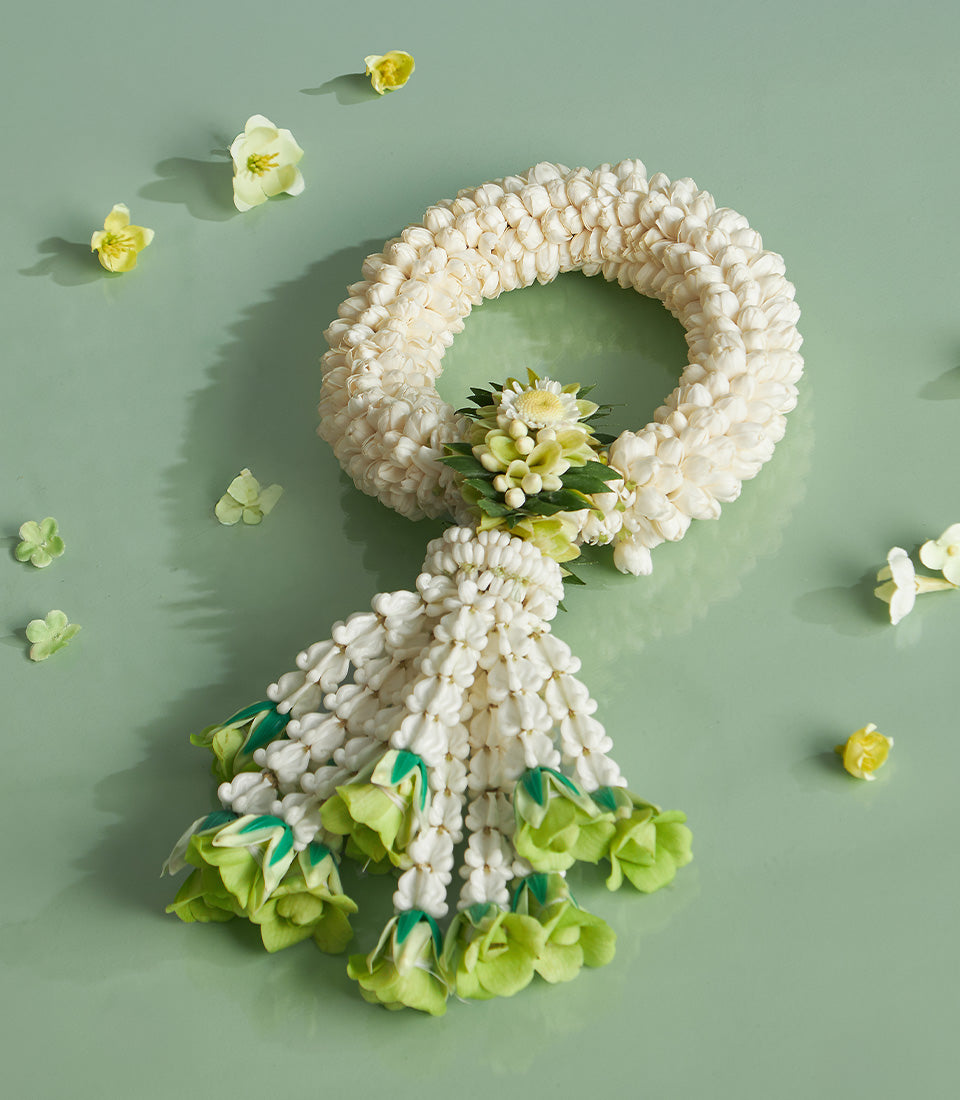 White jasmine phuang malai Thai New Year garland with pale green bell flowers and delicate green leaves