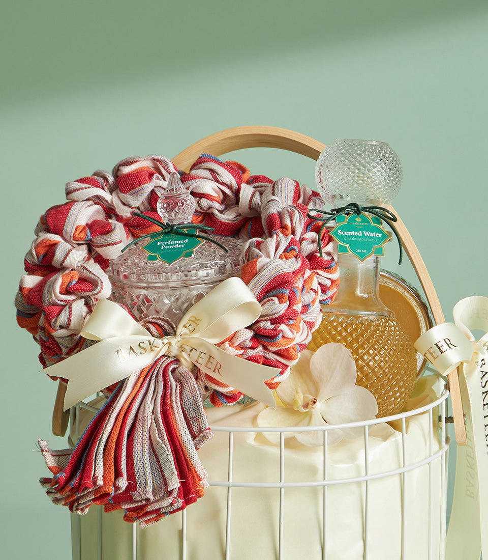 Thai Songkran blessing set with perfumed powder, scented water, and orchid in white wire gift basket