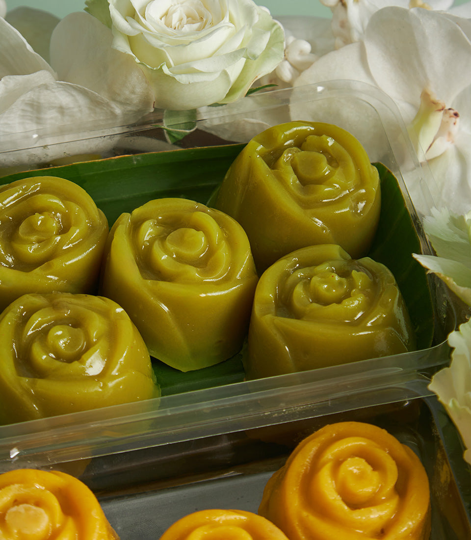 Songkran gift box with rose-shaped green and golden desserts, white roses and orchids
