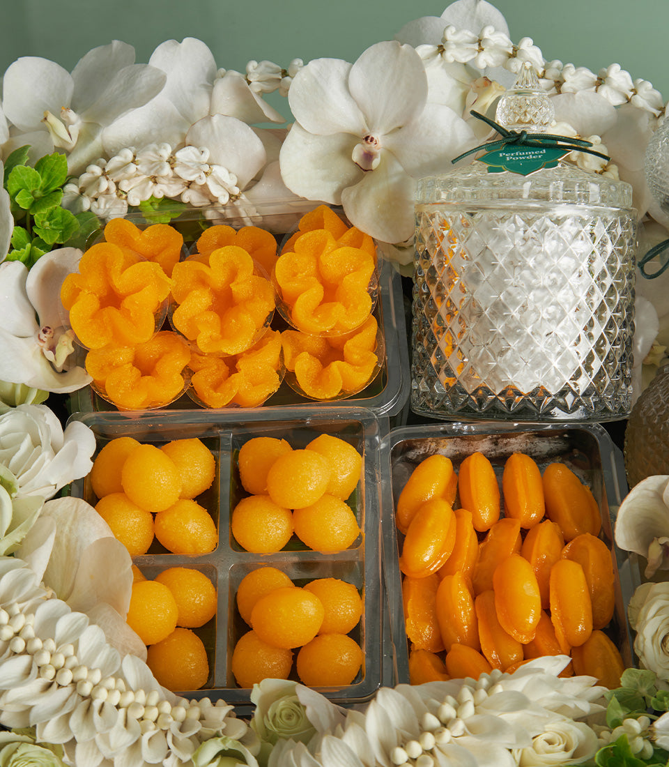 Thai golden dessert assortment with orchids and white flowers in luxury Songkran gift set