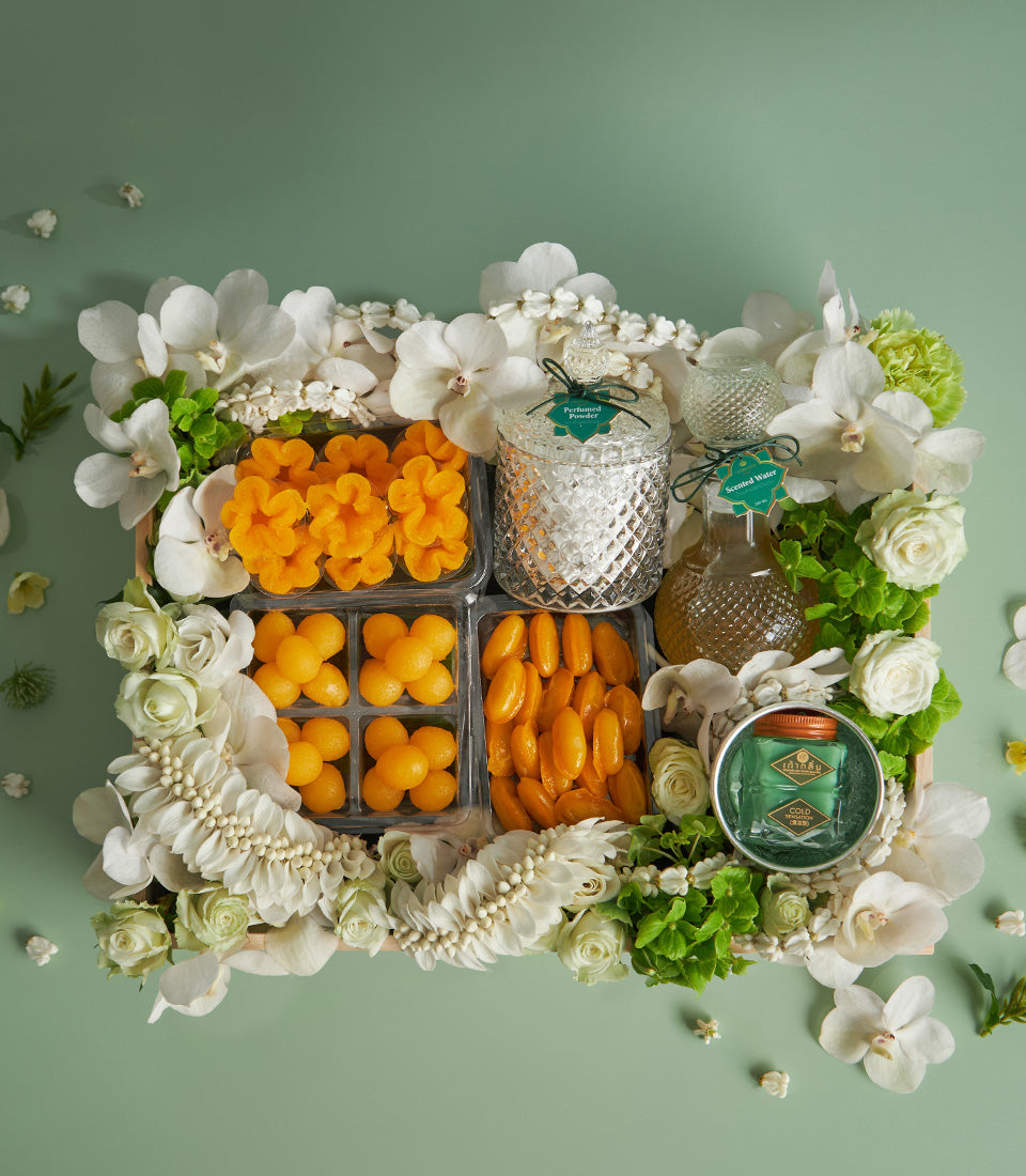 Thai auspicious dessert gift set with golden sweets, perfumed powder, and scented water in wooden tray, Thai New Year