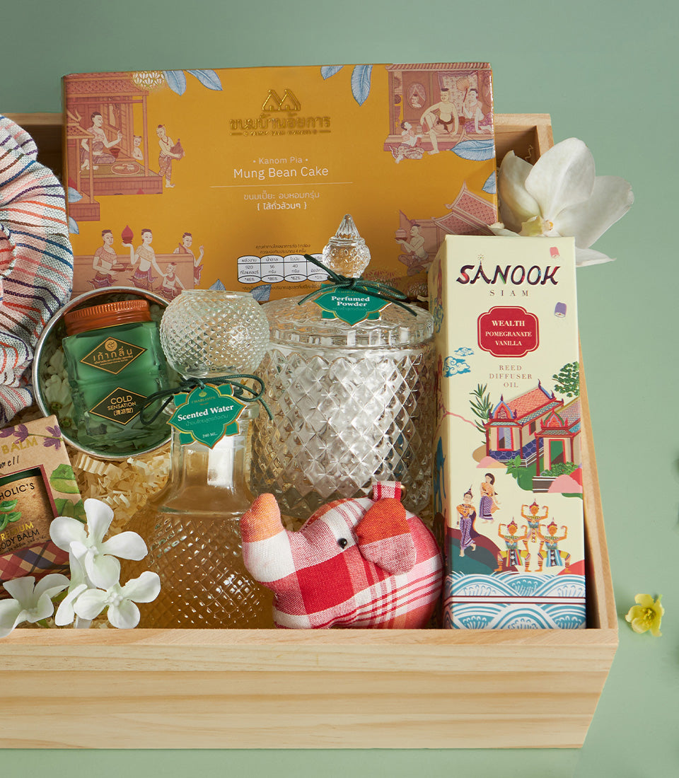 Wooden gift crate with Thai mung bean cakes, reed diffuser, perfumed powder, scented water, and fabric elephant for Songkran