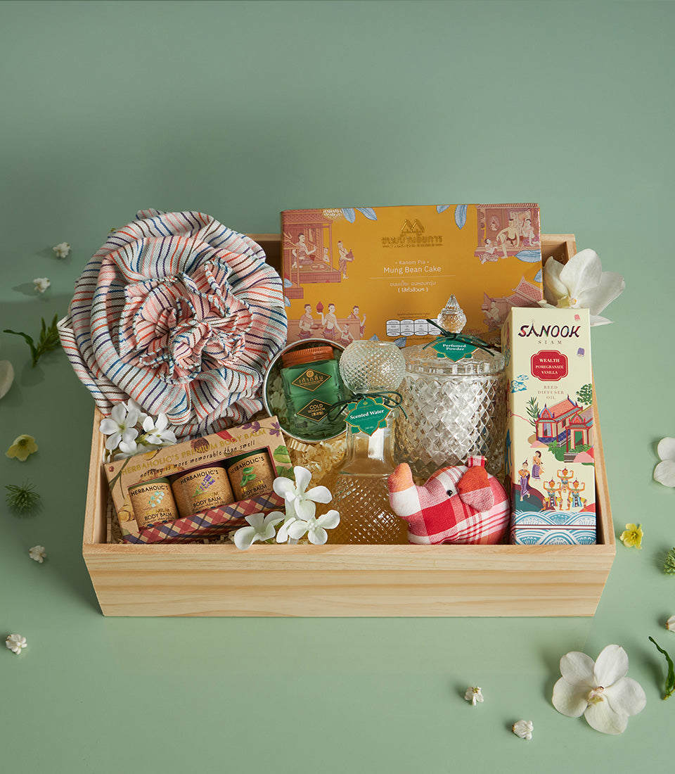 Premium Thai Songkran gift box with mung bean cake, scented water, striped fabric, and decorative elephant in wooden tray