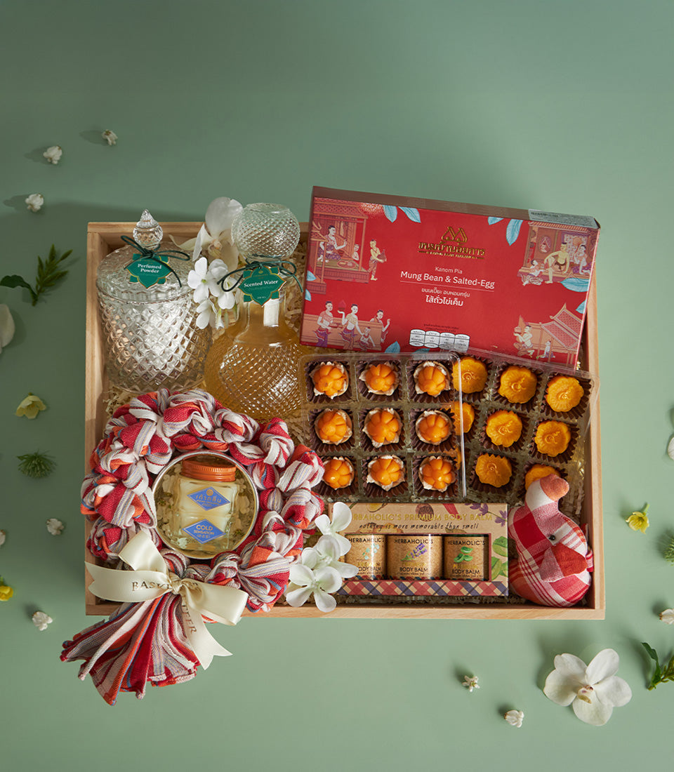 Wooden tray gift set with Thai treats, perfumed powder, scented water, mung bean pastries, and body balm for Songkran