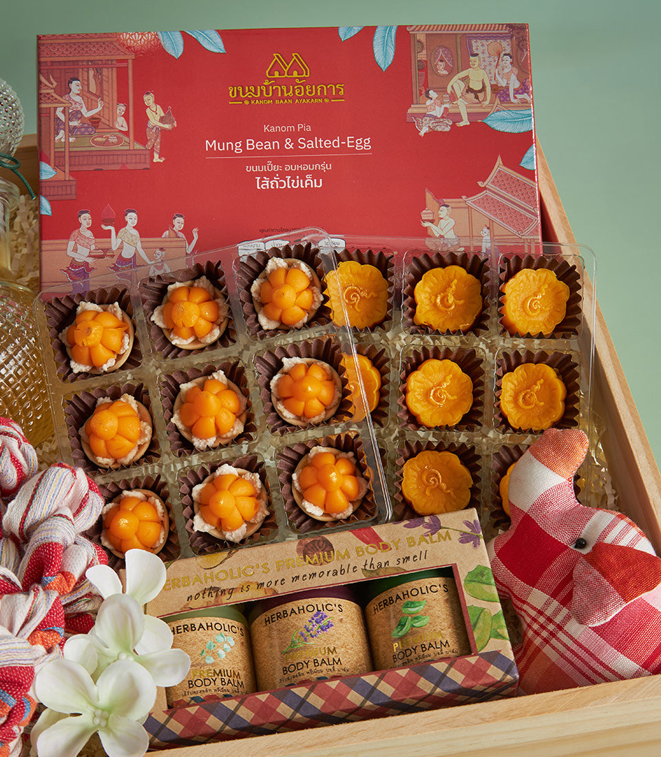 Songkran gift box with Thai mung bean pastries, salted-egg sweets, and premium body balm in wooden tray