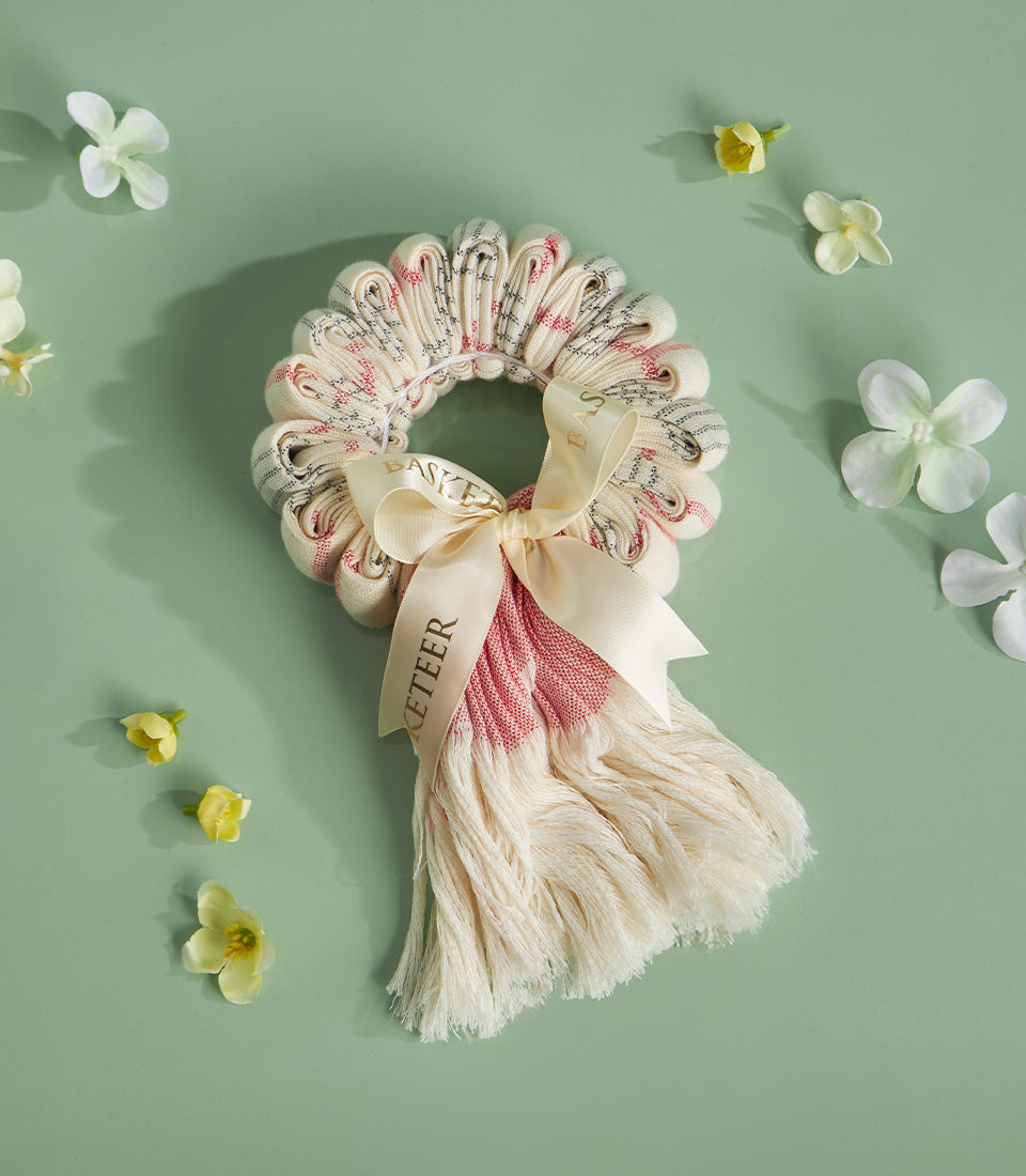 Pha-Kao-Ma Thai garland with striped cream fabric, satin ribbon bow, and festive fringe for Songkran celebrations