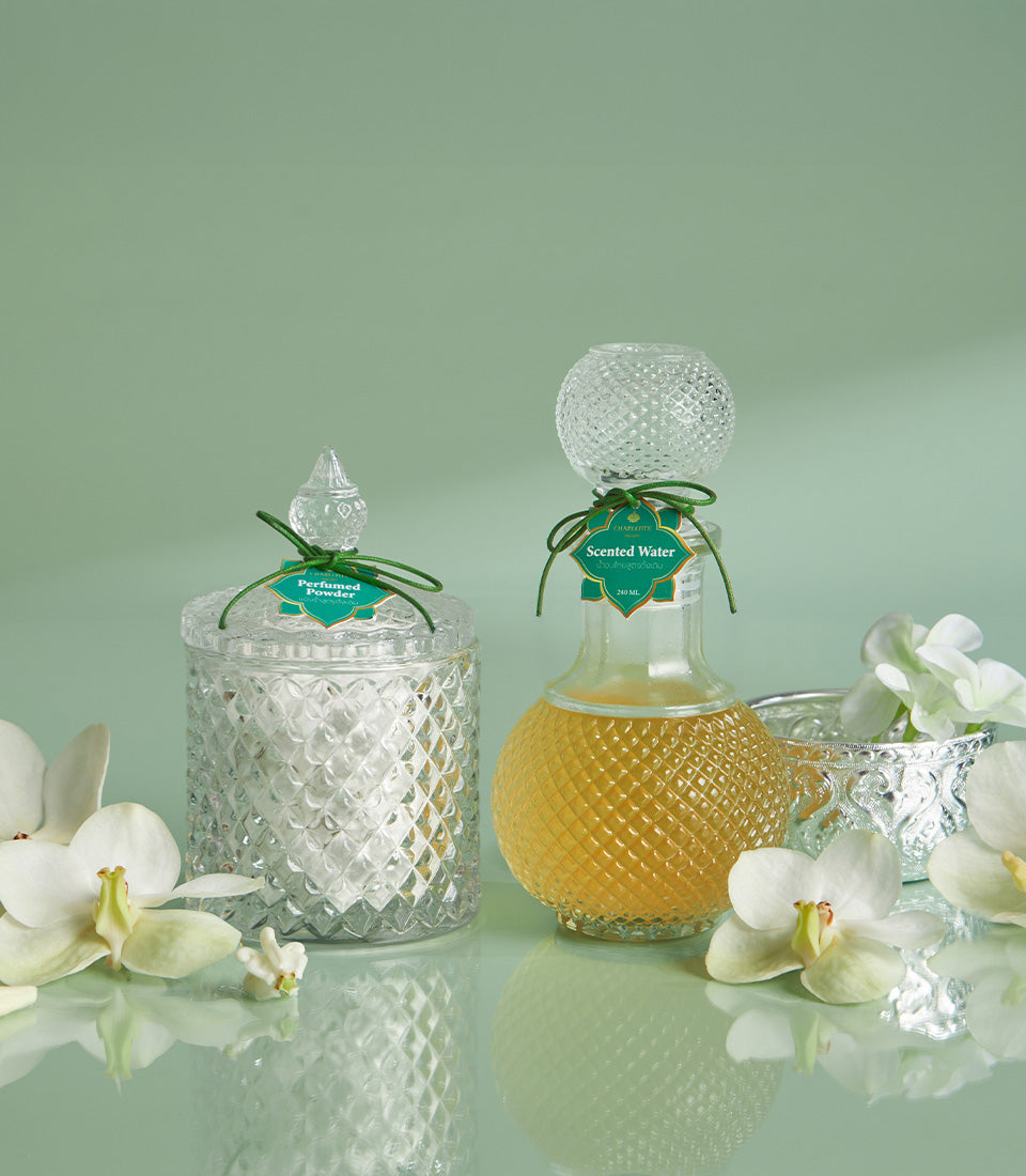 Graceful Thai Songkran gift set with perfumed powder, scented water, and white orchids in ornate glass containers