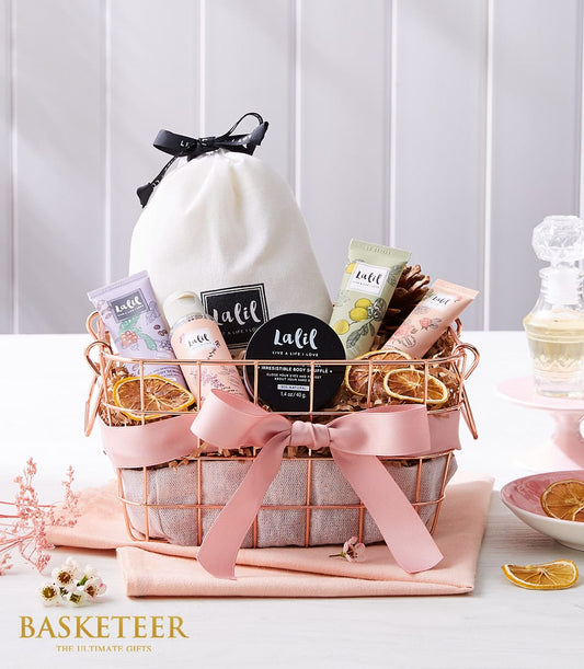Premium spa relaxation gift basket with rose gold wire, pink satin bow, skincare products and dried citrus accents