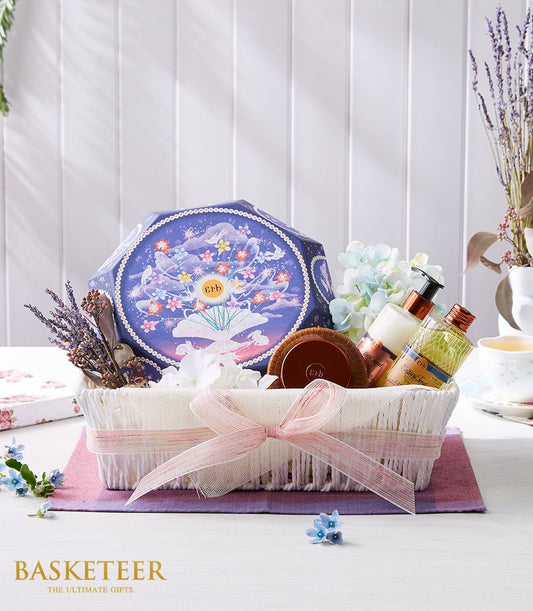 Luxe spa wellness gift basket with lavender, aromatherapy bottles, and purple celestial box on white woven basket