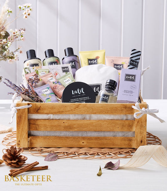 Luxury spa gift basket with pastel bath and body products, lavender, and soft linens in rustic wooden crate