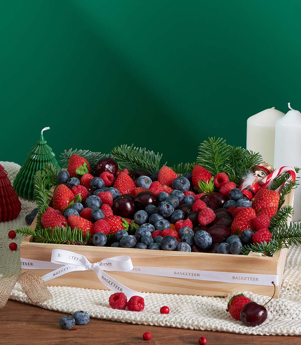 Festive mixed berry wooden gift box with strawberries, blueberries, raspberries, and pine, tied with Basketeer ribbon