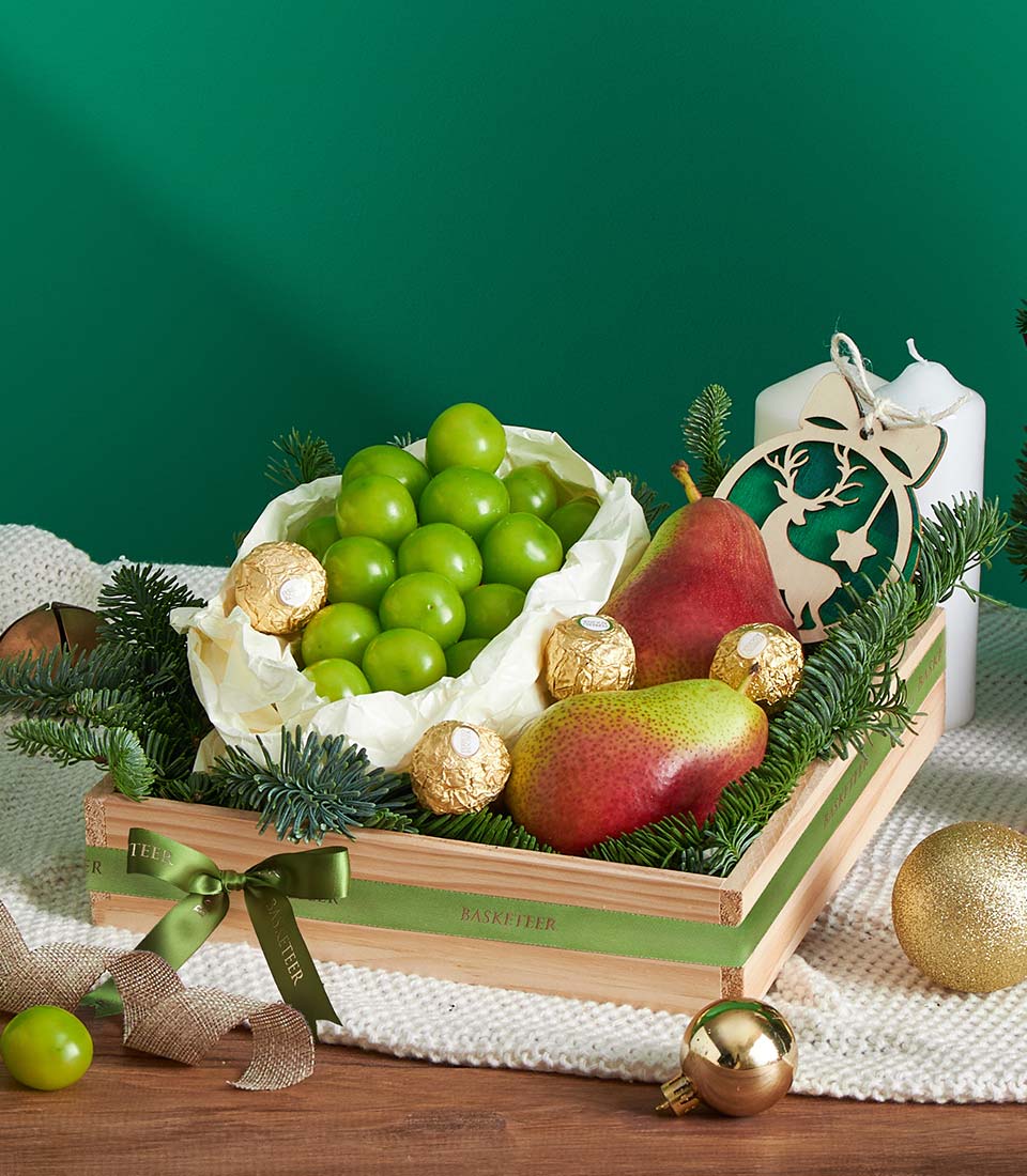 Festive wooden gift box with fresh fruit, Ferrero Rocher chocolates, and green ribbon for Christmas