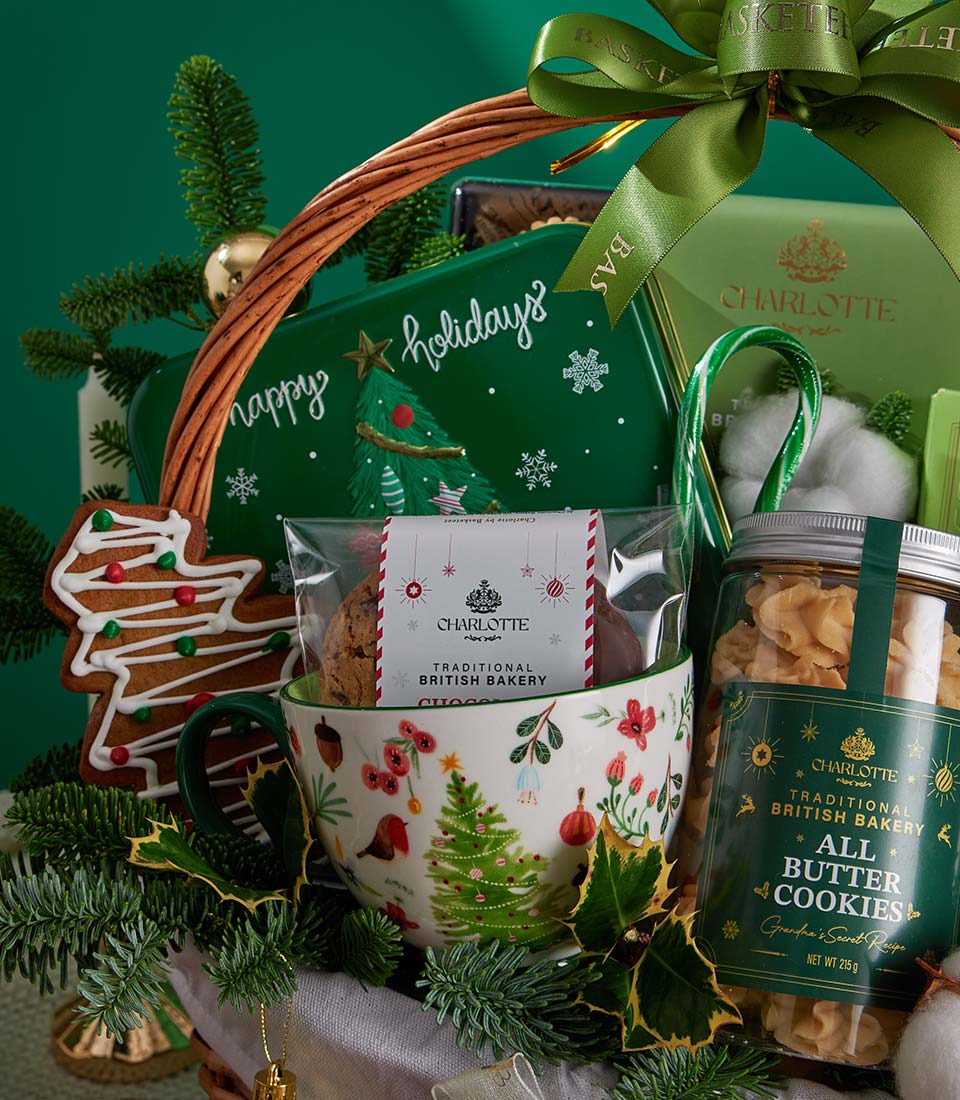 Festive Christmas gift basket with Charlotte Bakery cookies, chocolate, white mug, and green holiday trimmings