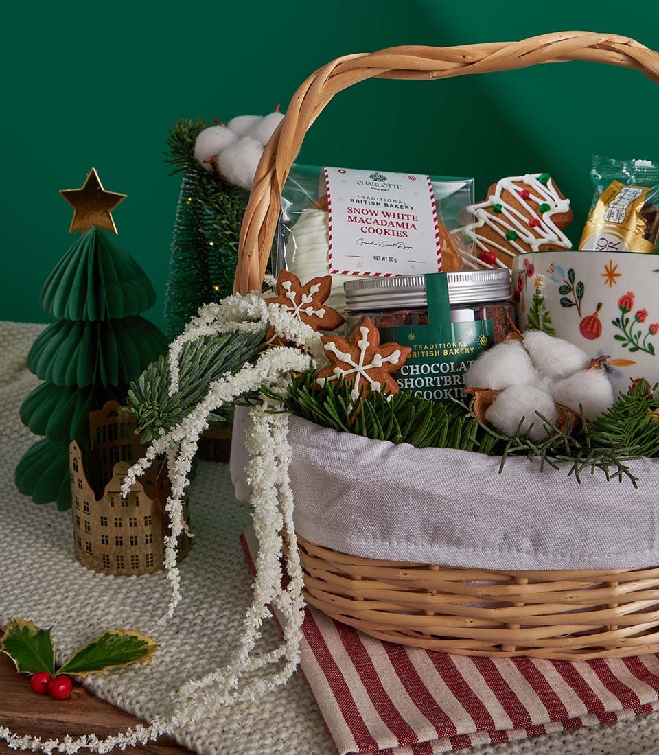 Festive Christmas shortbread and gingerbread gift basket with wicker hamper, baked goods, and holiday decorations