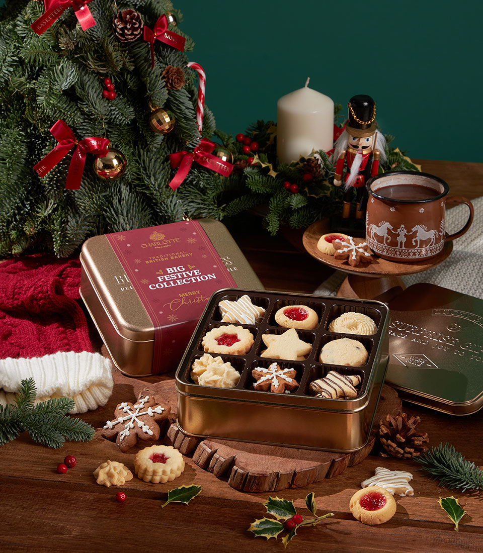 Gold tin of assorted Christmas cookies with star and snowflake shapes, festive bakery gift collection