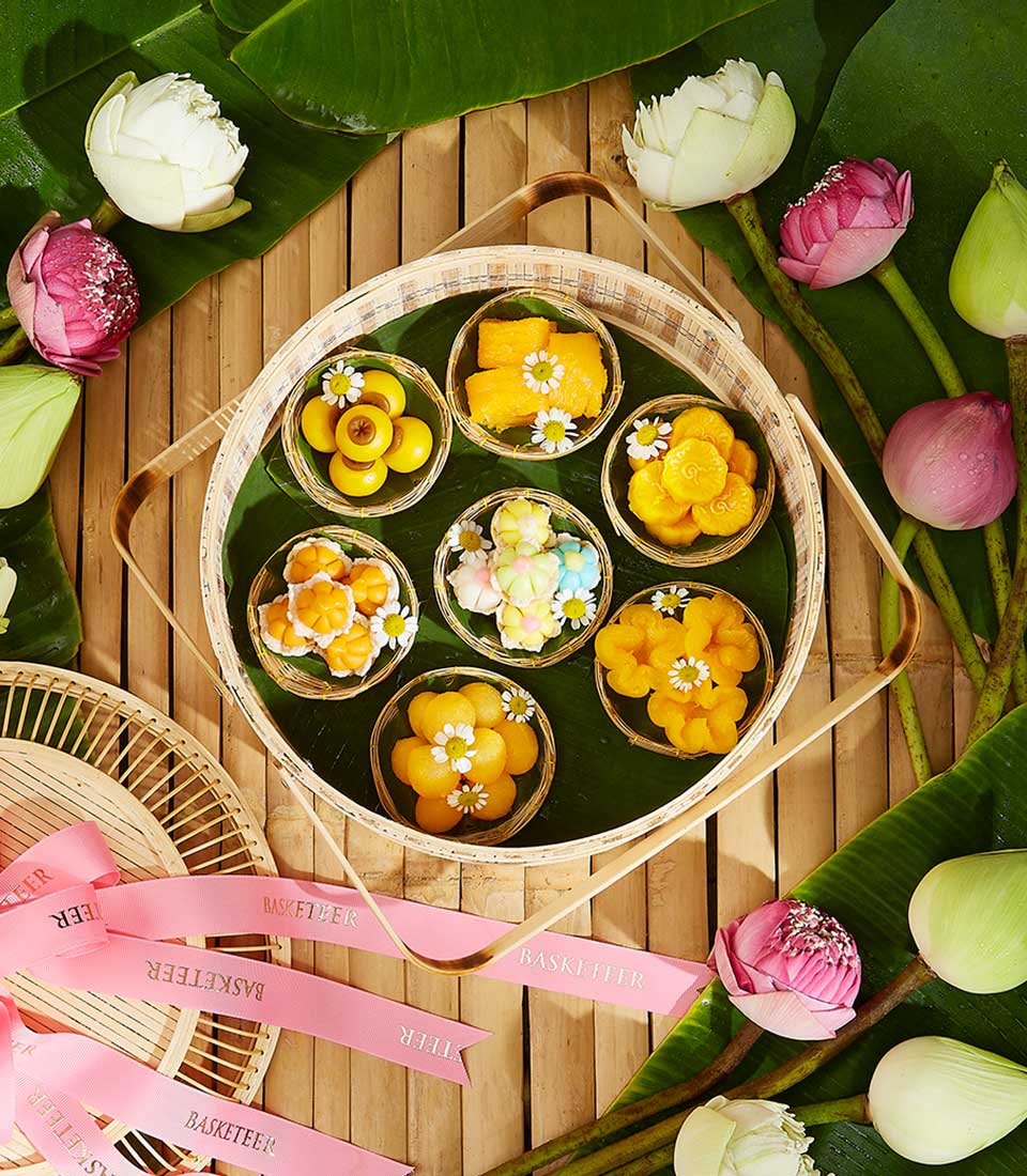 Assorted Thai desserts in woven bamboo basket with lotus flowers, Songkran New Year gift set