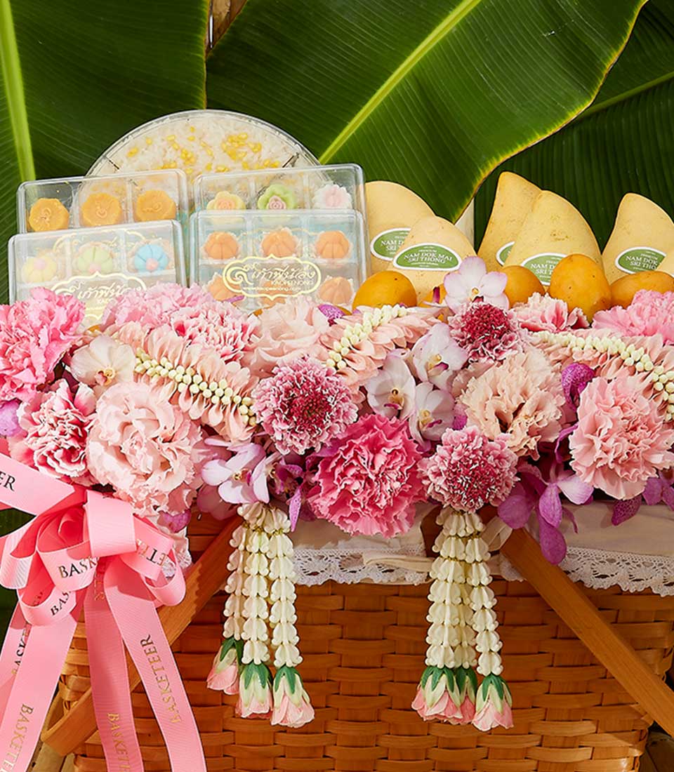 Thai Songkran gift basket with pink orchids, carnations, flower garlands, fresh mangoes and traditional desserts
