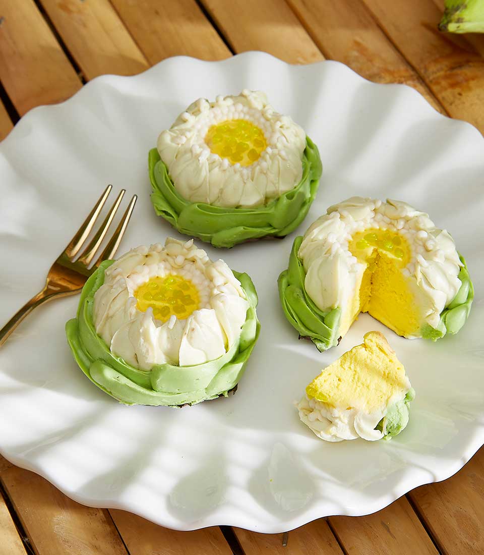 Lotus-shaped Thai desserts with white petals and yellow centers on ruffled plate, Songkran gift for elders