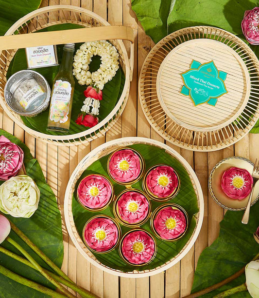 Thai New Year Songkran blessing set with jasmine garland, scented water, traditional kanom desserts, and fresh lotus flowers