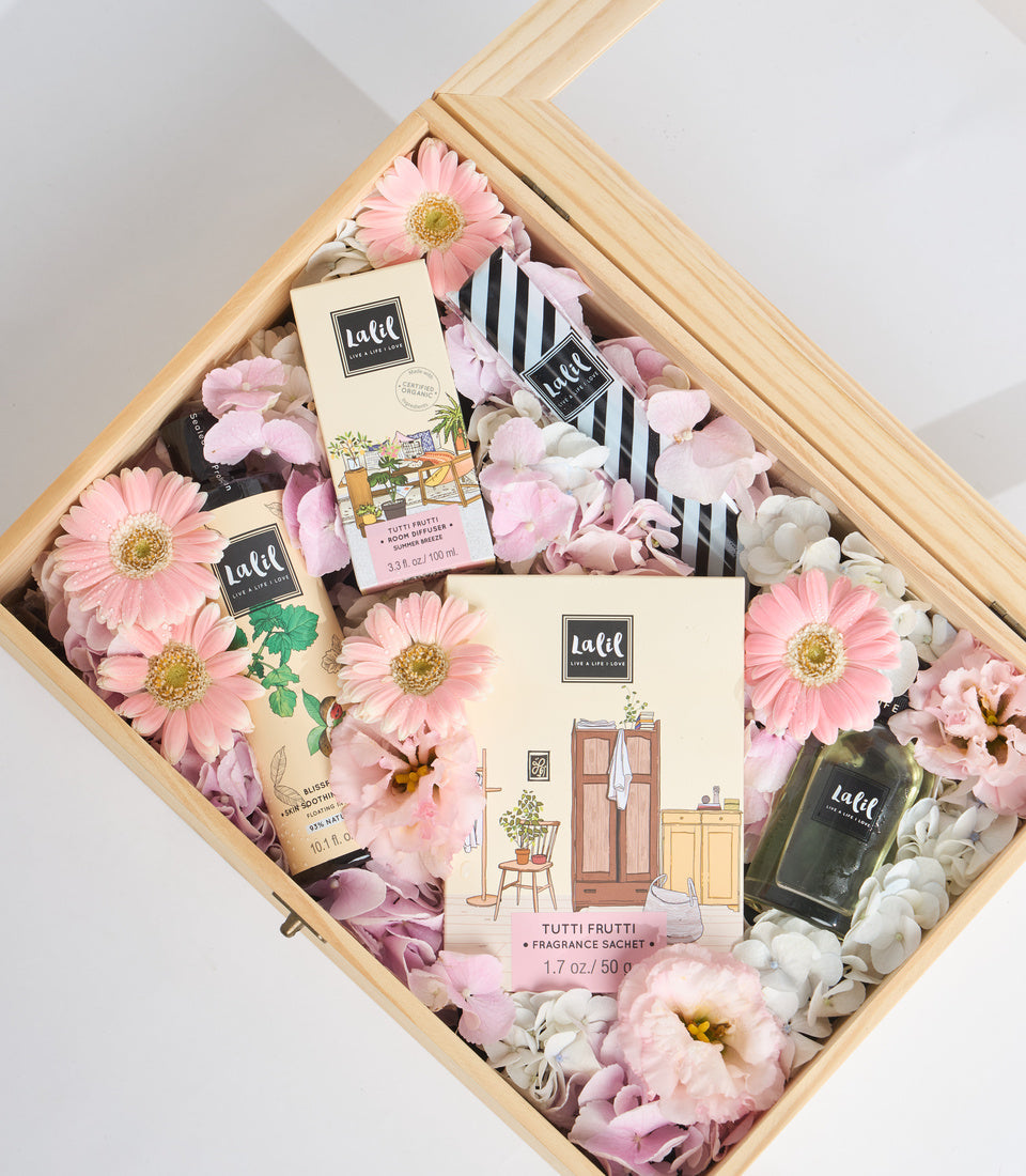 Luxury gift set in natural wood box with pink and white flowers, featuring Lafil fragrance products, striped pouch, and decorative sachets.