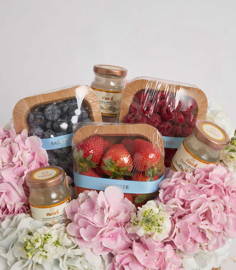 # Alt Text

Luxury gift basket with fresh berries, bird's nest products, and pink and white flowers on white background.