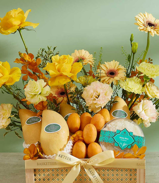 Premium Nam Dok Mai mango gift basket with fresh yellow roses, gerbera daisies, and tropical blooms in cream rattan