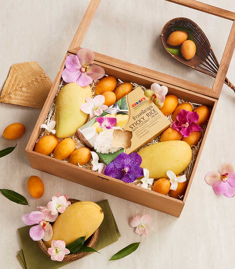 Tropical fruit gift box with yellow mangoes, plum mangoes, sticky rice dessert kit, and fresh orchids in wooden case