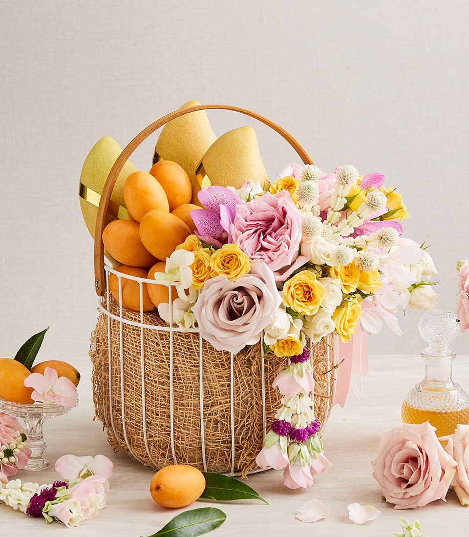 Woven fruit and flower gift basket with mangoes, tropical fruits, pink roses, and orchids for Songkran