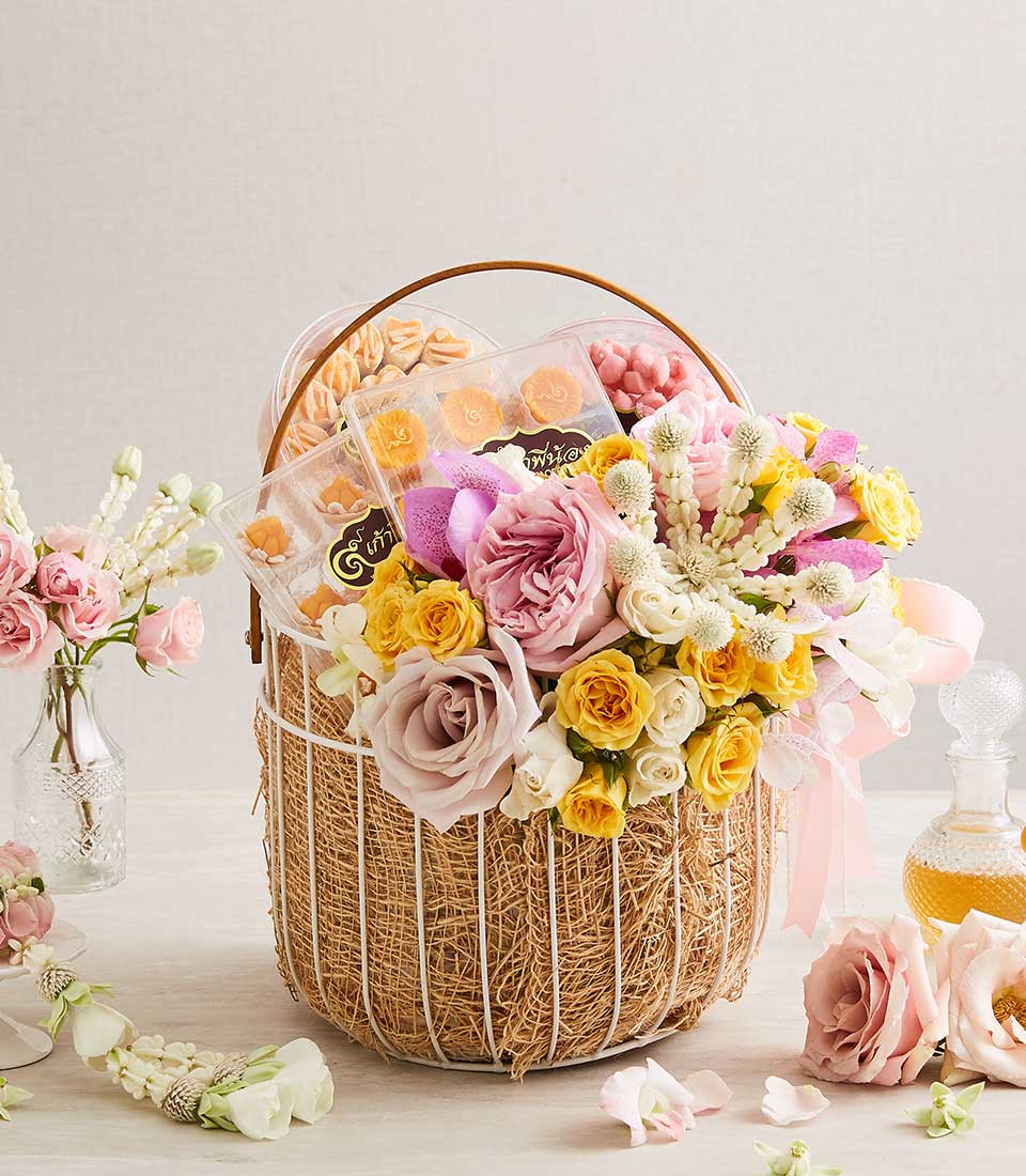 Pink and purple roses with jasmine garlands and Thai desserts in white wire gift basket for Songkran