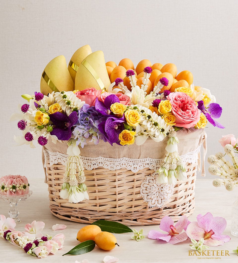 Golden mango and fresh Thai flowers luxury gift basket with roses, orchids, and traditional phuang malai garlands for